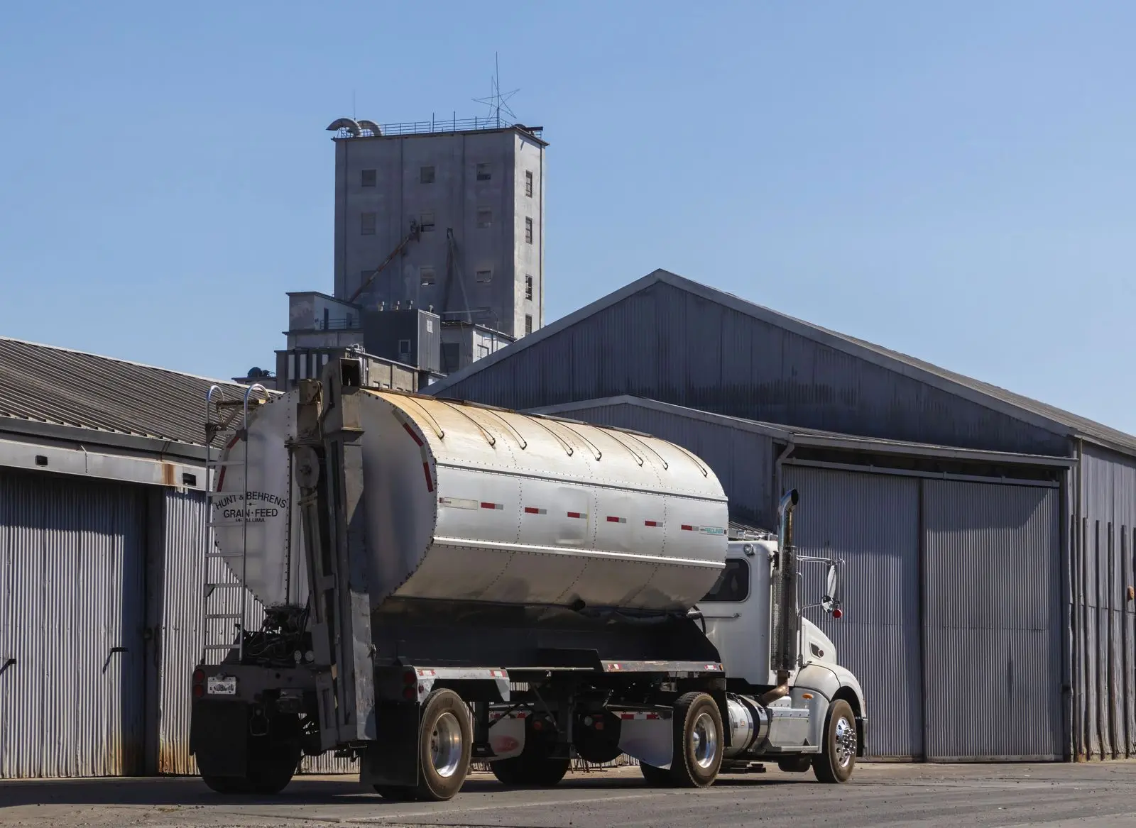 Camion-citerne devant des entrepôts industriels
