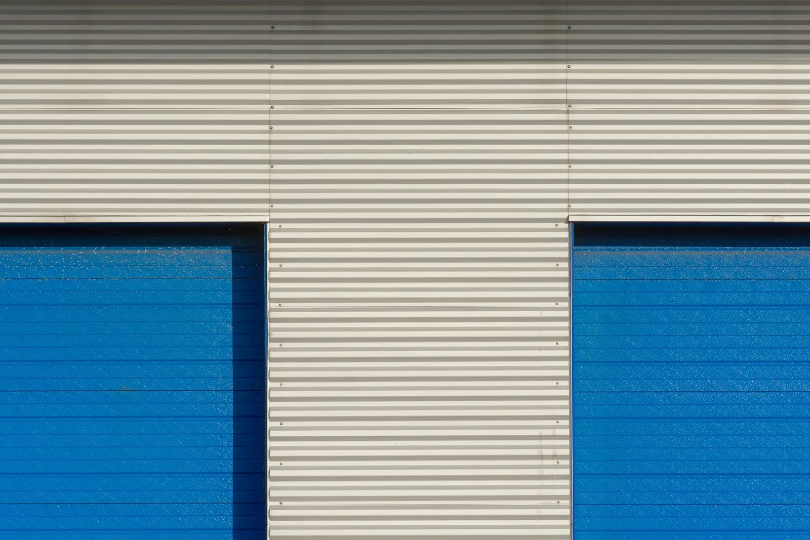 Façade d'entrepôt avec portes sectionnelles bleues