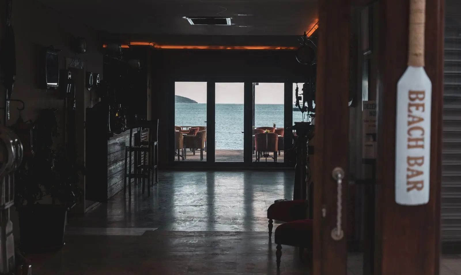 Bar de plage aux boiseries sombres ouvert sur la mer