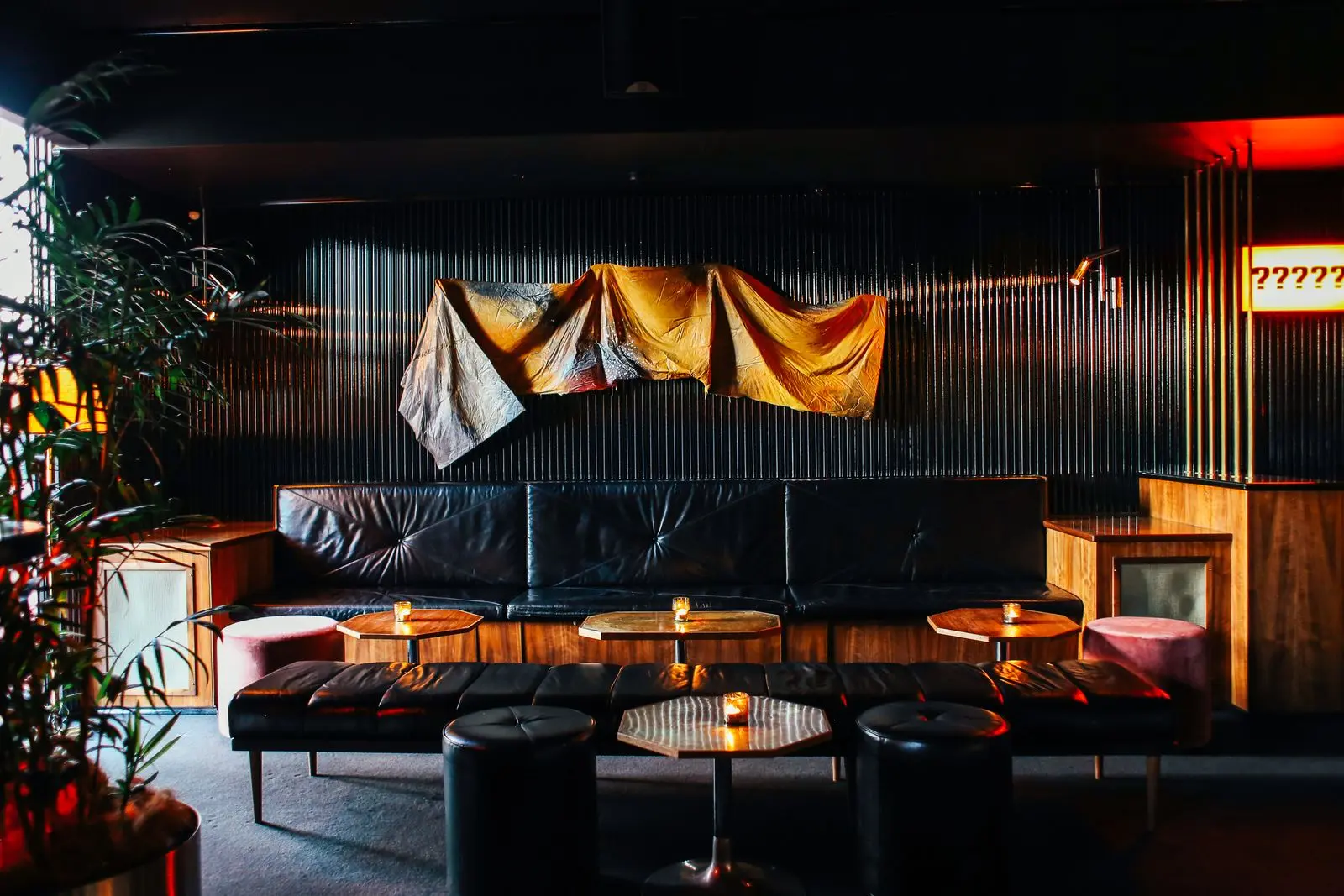 Salon lounge aux murs sombres et banquettes