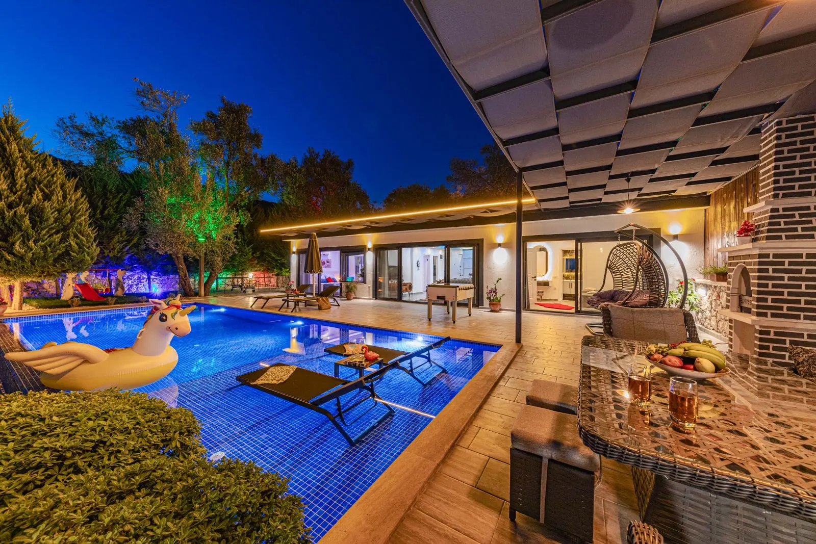Villa illuminée en soirée avec piscine bleue