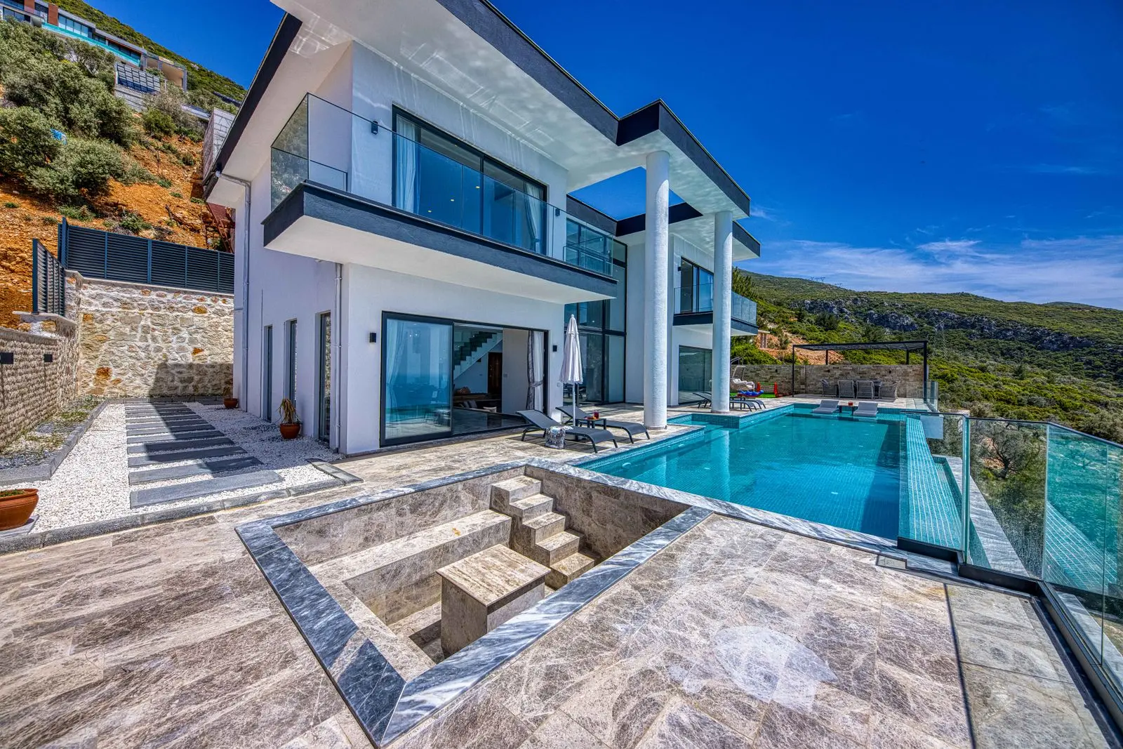 Villa blanche à plusieurs niveaux avec piscine à débordement