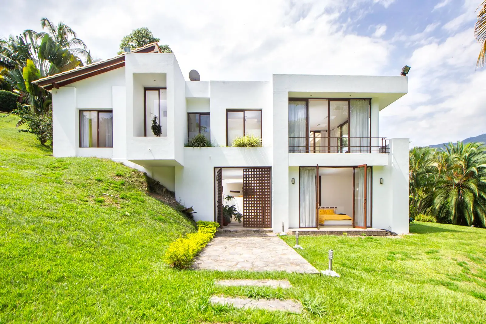 Villa blanche implantée sur un terrain en pente