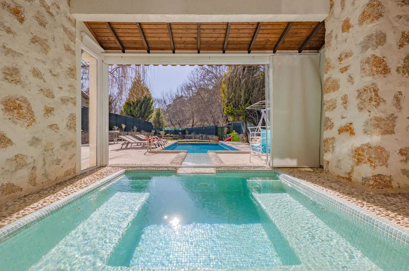 Piscine intérieure d'une villa aux murs de pierre